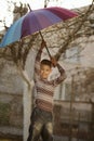 Happy boy with a rainbow umbrella in park Royalty Free Stock Photo