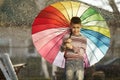 Happy boy with a rainbow umbrella in park Royalty Free Stock Photo