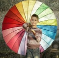 Happy boy with a rainbow umbrella in park Royalty Free Stock Photo