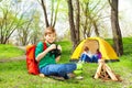 Happy boy with red backpack and binocular at camp