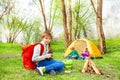 Happy boy with red backpack holds binocular