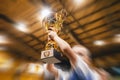 Happy boy rising golden cup, indoor sports celebration championship. Kids in the sports team lift up the golden cup trophy Royalty Free Stock Photo