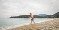 Happy boy run to the sea. Alone child have fun on beach, run by sea water pool. Active family lifestyle, kids outdoor Royalty Free Stock Photo