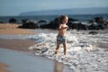 Happy boy running beach near the seaside. Excited amazed kid having fun with running through water in ocean or sea. Royalty Free Stock Photo