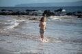 Happy boy running beach near the seaside. Excited amazed kid having fun with running through water in ocean or sea. Royalty Free Stock Photo