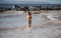 Happy boy running beach near the seaside. Excited amazed kid having fun with running through water in ocean or sea. Royalty Free Stock Photo