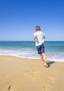 Happy boy running and playing on the summer beach. Young teenager relax and having fun in summer holiday vacation travel Royalty Free Stock Photo