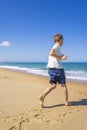 Happy boy running and playing on the summer beach. Young teenager relax and having fun in summer holiday vacation travel Royalty Free Stock Photo