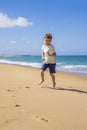 Happy boy running and playing on the summer beach. Young teenager relax and having fun in summer holiday vacation travel Royalty Free Stock Photo