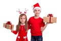Happy boy with santa hat on his head and a girl with deer horns, holding the gift boxes in their hands. Concept