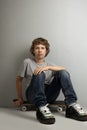 Happy boy sitting on skateboard Royalty Free Stock Photo