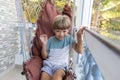 Happy boy is sitting, swinging in rattan swing chair during summer holidays at hotel having fun. Royalty Free Stock Photo