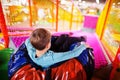 Happy boy sitting in tubing donuts enjoying slides in fun children center