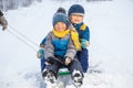 Happy boy on sled. Child playing in winter snow Royalty Free Stock Photo