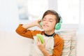 Happy boy with smartphone and headphones at home Royalty Free Stock Photo