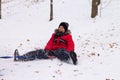 A boy in a red jacket down on a sled with a snow slide Royalty Free Stock Photo