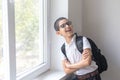 Happy boy in spectacles and shirt near the school window. Isolated over white background. Schoolboy. Teenager. Royalty Free Stock Photo