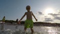 Happy boy splashes sea water at camera. Child body tempering at summer holidays.