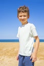 Happy boy standing on the summer beach. Young teenager relax and having fun in summer holiday vacation travel. Royalty Free Stock Photo