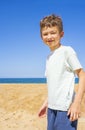 Happy boy standing on the summer beach. Young teenager relax and having fun in summer holiday vacation travel. Royalty Free Stock Photo