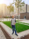 happy boy stands in yard of his new home in modern residential complex business class
