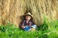 Happy boy in straw hat sitting in haystack Royalty Free Stock Photo