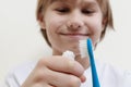 Happy boy taking toothpaste and preparing to brush his teeth with toothbrush