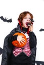 Happy boy in a vampire costume holding a pumpkin