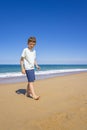 Happy boy walking and playing on the summer beach. Young teenager relax and having fun in summer holiday vacation travel Royalty Free Stock Photo