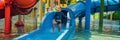 Happy boy on water slide in a swimming pool having fun during summer vacation in a beautiful tropical resort BANNER Royalty Free Stock Photo