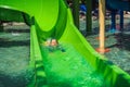 Happy boy on water slide in a swimming pool having fun during summer vacation in a beautiful tropical resort Royalty Free Stock Photo