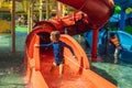 Happy boy on water slide in a swimming pool having fun during summer vacation in a beautiful tropical resort Royalty Free Stock Photo
