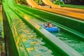 Happy boy on water slide in a swimming pool having fun during summer vacation in a beautiful tropical resort Royalty Free Stock Photo