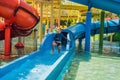 Happy boy on water slide in a swimming pool having fun during summer vacation in a beautiful tropical resort Royalty Free Stock Photo