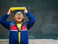 Happy Boy wear glasses smiling and stand in front of the blackboard. Back to School, Education Concept. Royalty Free Stock Photo