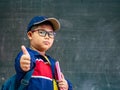 Happy Boy wear glasses smiling and stand in front of the blackboard. Back to School, Education Concept. Royalty Free Stock Photo