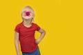 Happy boy wearing clown nose and smiling at camera. Portrait of kid on yellow background. Copy space Royalty Free Stock Photo