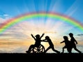 Happy boy in wheelchair playing with children rainbow day