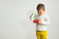 A happy boy is hold top cover a gift. Child looks inside a red Royalty Free Stock Photo