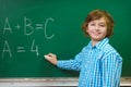 Happy boy writing on blackboard background. Educational and school concept Royalty Free Stock Photo