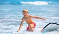 Young surfer learning ride, jump from surfboard, run to beach Royalty Free Stock Photo