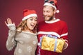 Happy boyfriend surprising his girlfriend giving her a christmas present - Young couple having fun celebrating xmas holidays Royalty Free Stock Photo