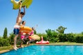 Kids hold inflatable toys dive into the water pool Royalty Free Stock Photo