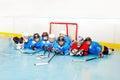 Happy boys and girls laying on ice hockey rink