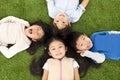 Boys and girls lying on green grass