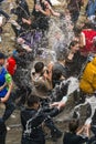 Happy boys & girls pouring water on each other.