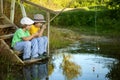 Happy boys go fishing on the river, Two children of the fisherman with a fishing rod on the shore of lake Royalty Free Stock Photo