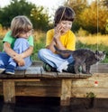 Happy boys go fishing on the river, Two children of the fisherman with a fishing rod on the shore of lake Royalty Free Stock Photo