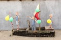 Happy boys play pirates and seafarers. Three brothers have fun together. The old boat is decorated with balloons Royalty Free Stock Photo