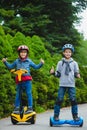 Happy boys riding on hoverboards or gyroscooters outdoor